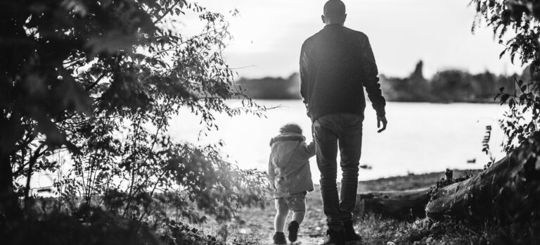 A father walking with his child by a river